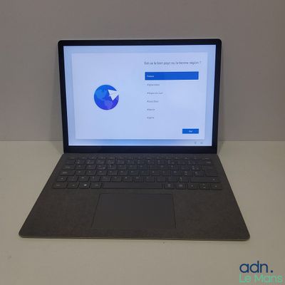 une image représentant un ordinateur portable posé sur une table, avec une souris à côté