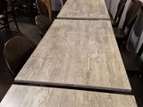 une longue table avec des chaises et une couronne accrochée au mur