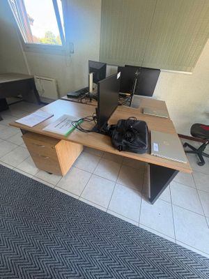 a desk with two computer monitors and a backpack on it