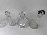 three wine glasses and a bottle on a table