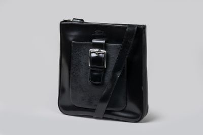 un sac en cuir noir muni d'une boucle métallique sur le devant