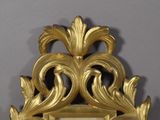 a mirror with a gold frame on a wall
