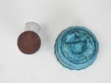 a small blue bowl next to a penny on a white surface