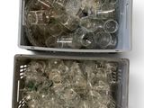 two bins filled with empty plastic bottles on a white surface