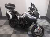 une moto noire et blanche garée sur un sol à damier
