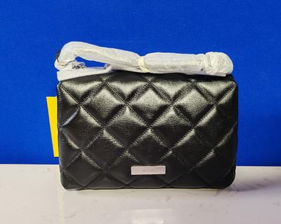 black quilted purse with a white bow on top of it