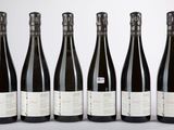 six bouteilles de vin sont alignées dans une rangée