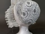 un chapeau blanc orné d'un motif en dentelle sur le dessus