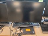 trois écrans d'ordinateur et un clavier posés sur un bureau