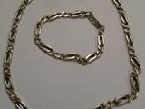 collier et bracelet en métal argenté sur fond blanc