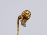 a gold statue of a woman with a flower in her hair