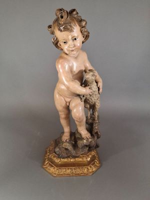 an antique statue of a child holding a bird on top of a table