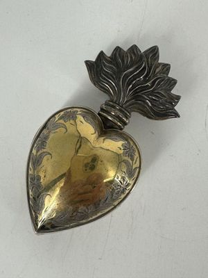 un fermoir en forme de cœur, en argent et en or, orné d'une feuille