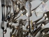 a lot of spoons and forks on the table