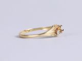 a close up of a yellow gold ring with a brown diamond