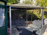 a patio area with a couch, chairs, and a gazebo