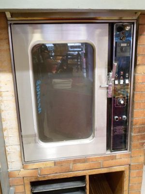 a silver oven that is sitting on a brick wall