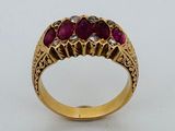 un gros plan d'une bague en or sertie de trois rubis