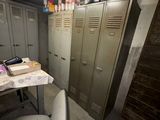 many lockers in a room with a table and a chair
