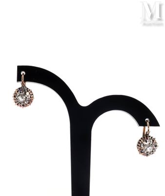 a close up of a pair of earrings on a stand