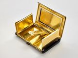 une petite boîte en or contenant une paire de ciseaux