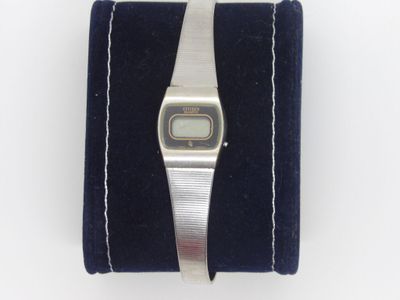 an image of a wrist watch sitting on top of a blue velvet case