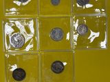 Plusieurs types de pièces sont exposés sur un support jaune