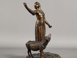 bronze statue of a woman and a dog on a rock
