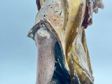 an antique statue of a woman holding a bird on a wooden base