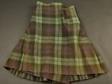 plaid skirt with pleas and buttons on the bottom of the skirt