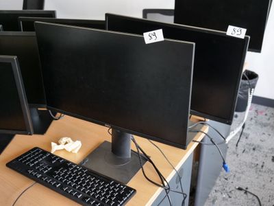 trois écrans d'ordinateur et un clavier posés sur un bureau dans un bureau