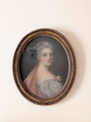 portrait d'une femme en robe bleue, avec une fleur bleue dans les cheveux