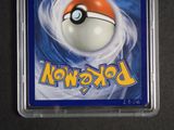a pokemon card in a plastic case on a table