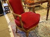 a red chair in a living room with a blue rug
