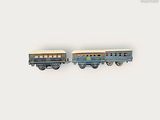 deux petits trains miniatures posés côte à côte sur une surface blanche