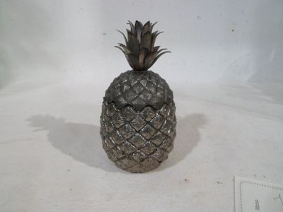 a silver pineapple sitting on a white surface