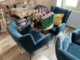 several chairs and a table with bottles of wine on it