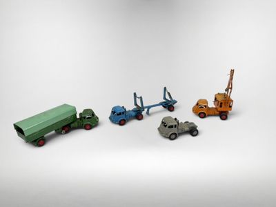 quatre camions miniatures et une grue sur fond blanc