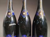 trois bouteilles de champagne sont alignées sur une table