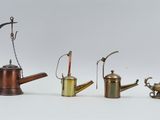 several different types of brass watering canisters on a white surface