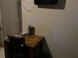 un petit bureau sur lequel est posée une télévision, dans une petite pièce