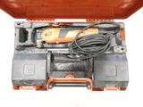 une perceuse à fil orange dans un coffret avec d'autres outils