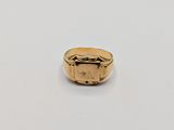 a close up of a gold ring on a white surface