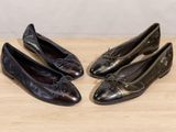 three pairs of women ' s black leather shoes on a wooden surface