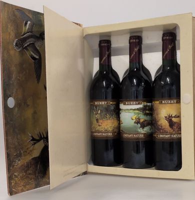 trois bouteilles de vin dans un coffret en bois sur une table