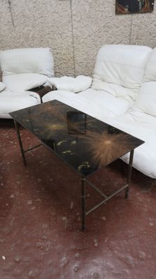 un canapé et une table dans une pièce où est accroché un tableau au mur