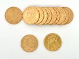 de nombreuses pièces d'or posées sur une surface blanche