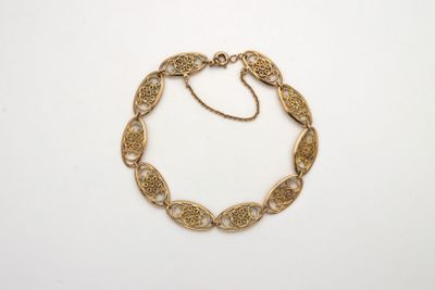 une image d'un bracelet en or sur fond blanc