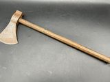 une vieille hache au manche en bois posée sur une table