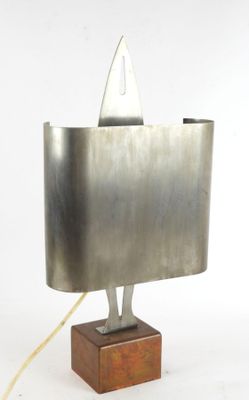 a metal sculpture of a shark on a wooden base